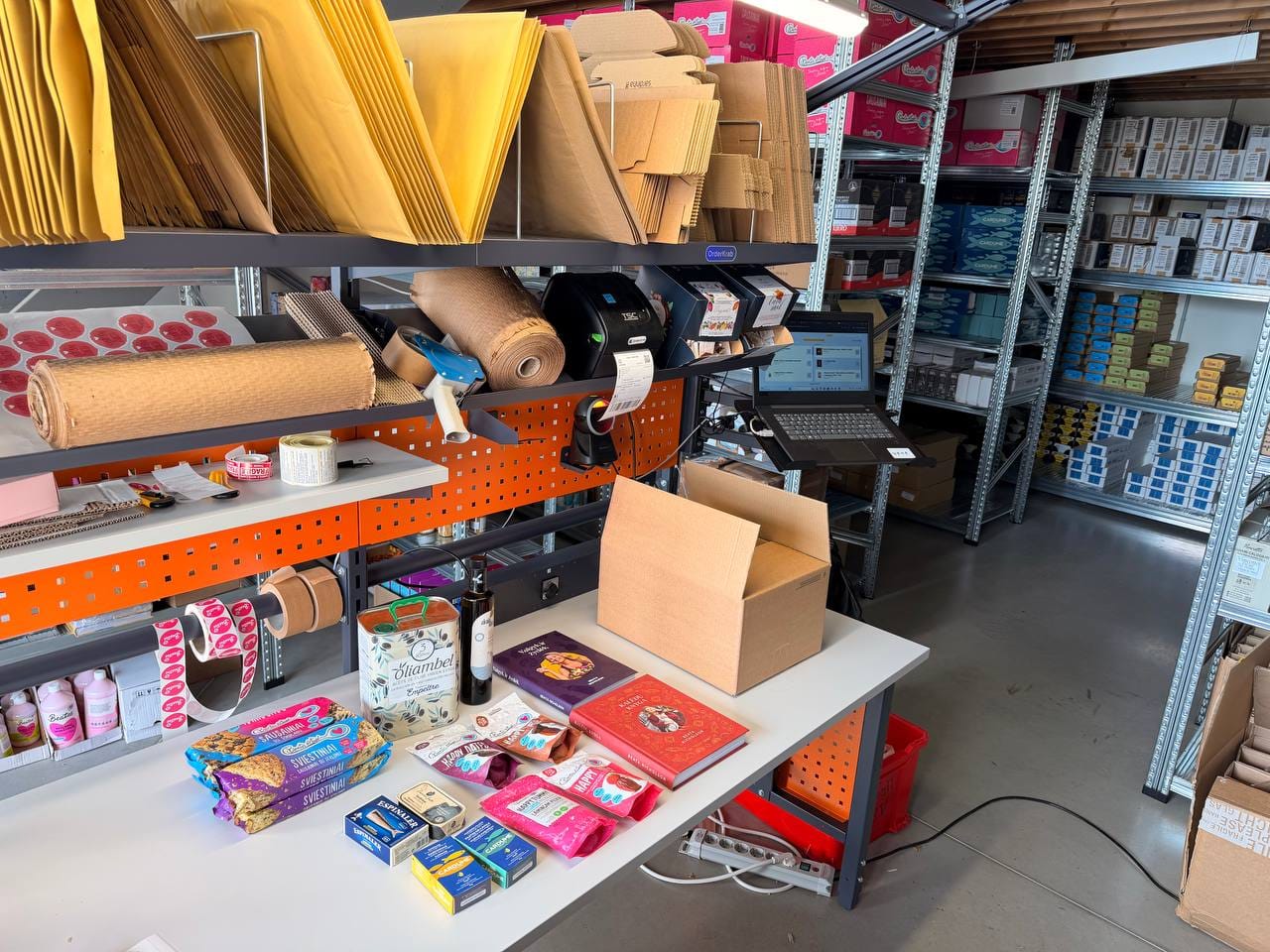 The Beatos packing desk with a label printer, a barcode scanner, a laptop and products waiting to be packed